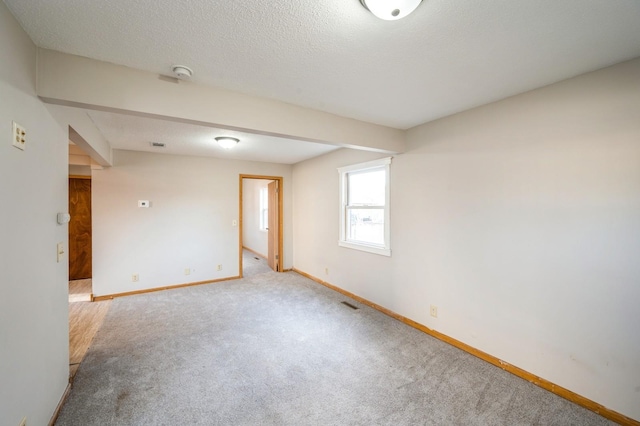 unfurnished room featuring light colored carpet and a textured ceiling