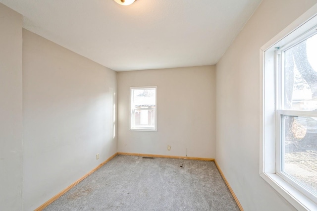 spare room featuring baseboards and carpet