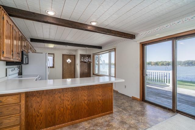 kitchen with beamed ceiling, kitchen peninsula, white appliances, a chandelier, and a water view