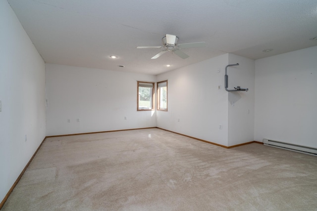 carpeted spare room featuring a baseboard heating unit and ceiling fan