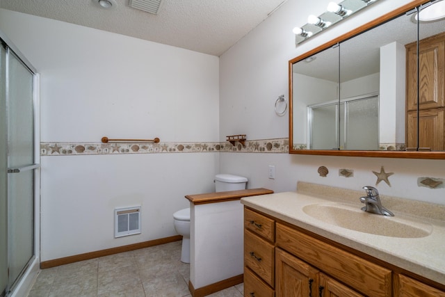 bathroom with a textured ceiling, vanity, toilet, and an enclosed shower