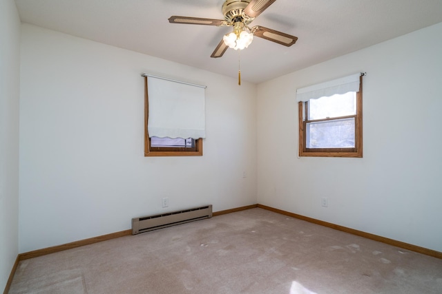 carpeted empty room with ceiling fan and a baseboard radiator