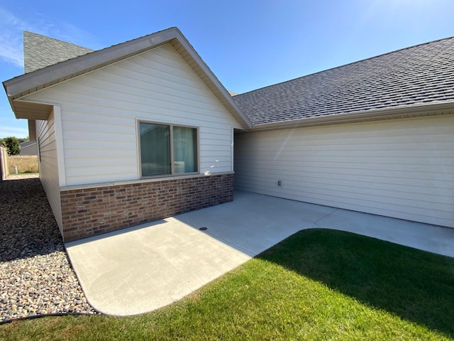 back of property with a lawn and a patio