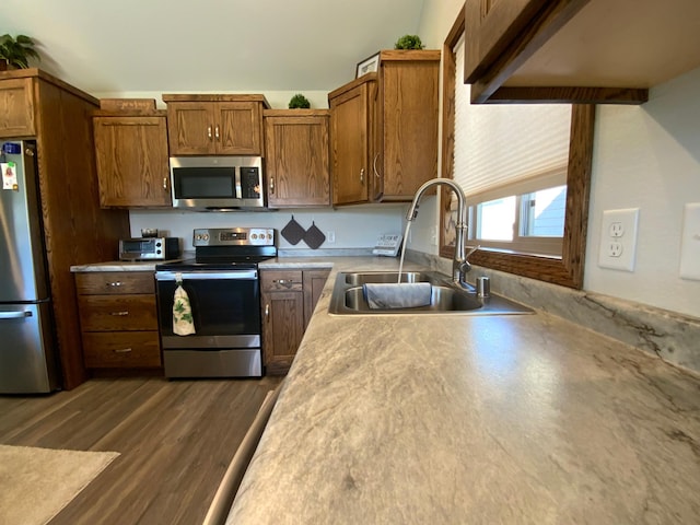 kitchen with sink, stainless steel appliances, and dark wood-type flooring