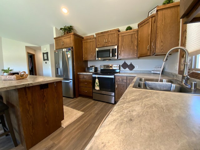 kitchen featuring stainless steel appliances, dark wood-type flooring, and sink