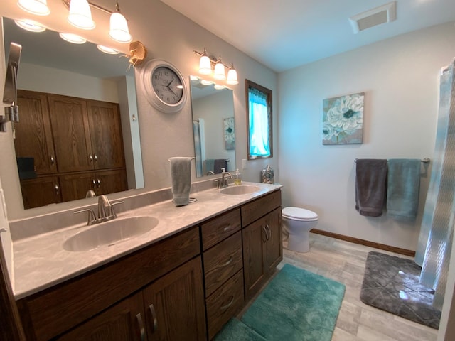 bathroom with wood-type flooring, vanity, and toilet