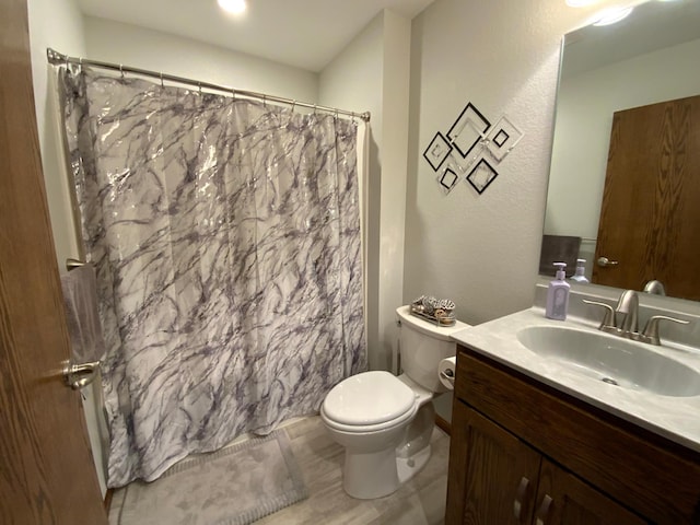 bathroom featuring curtained shower, vanity, and toilet