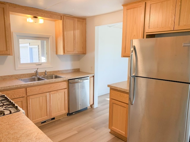 kitchen featuring appliances with stainless steel finishes, sink, light brown cabinetry, and light hardwood / wood-style floors