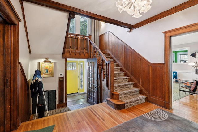 1920 Pillsbury Ave S, Minneapolis, MN 55403 - stairs with a chandelier, hardwood / wood-style floors, a wainscoted wall, and crown molding