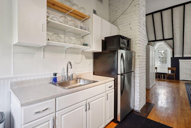 1920 Pillsbury Ave S, Minneapolis, MN 55403 - kitchen featuring a sink, freestanding refrigerator, black microwave, wood-type flooring, and light countertops