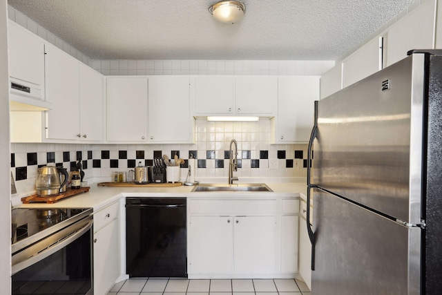 kitchen with decorative backsplash, white cabinets, sink, light tile patterned flooring, and appliances with stainless steel finishes