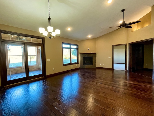 unfurnished living room with dark wood-type flooring, ceiling fan with notable chandelier, and vaulted ceiling