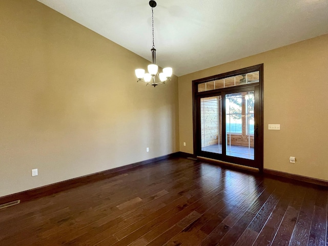 unfurnished room with dark wood-type flooring and a notable chandelier