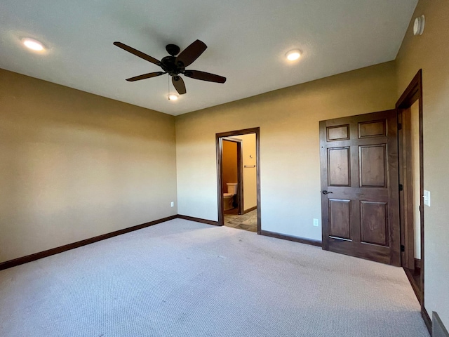 unfurnished bedroom featuring connected bathroom, ceiling fan, and light colored carpet