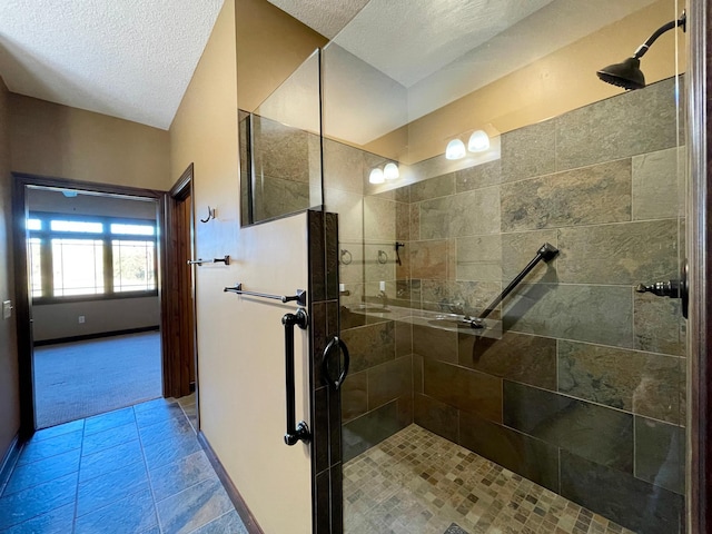 bathroom featuring tile patterned floors, a tile shower, and a textured ceiling