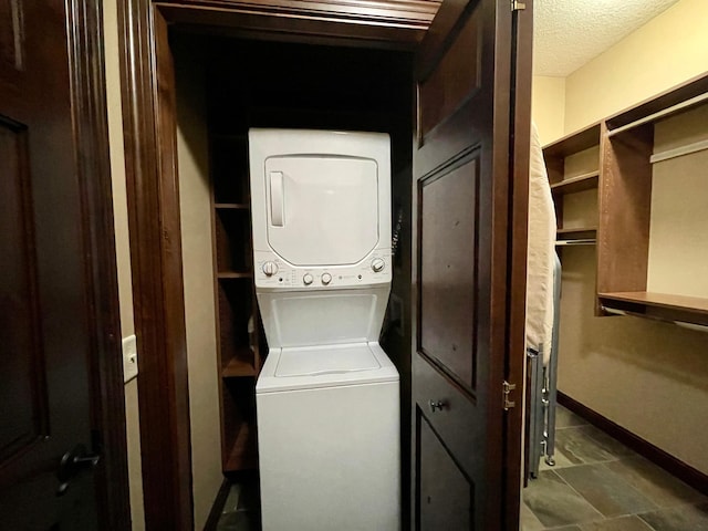 laundry area featuring a textured ceiling and stacked washer and clothes dryer