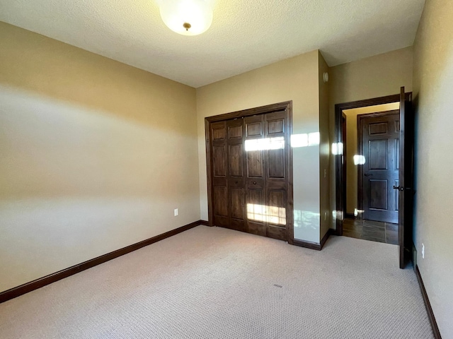 unfurnished bedroom featuring a closet, a textured ceiling, and carpet floors