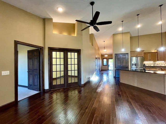 kitchen with dark wood-type flooring, stainless steel refrigerator with ice dispenser, high vaulted ceiling, and french doors