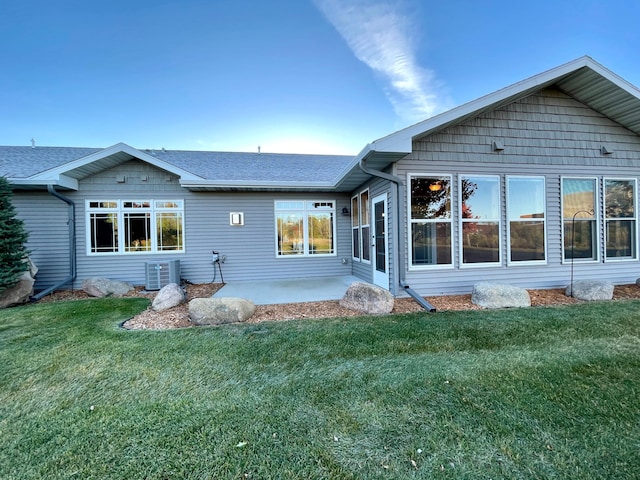 rear view of property with cooling unit and a yard