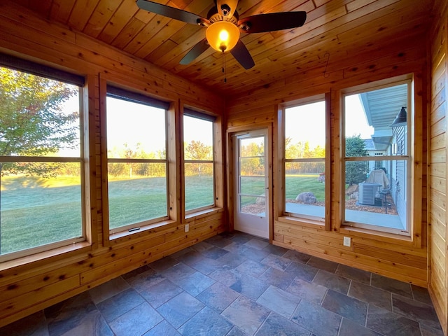 unfurnished sunroom with wood ceiling, a healthy amount of sunlight, and ceiling fan