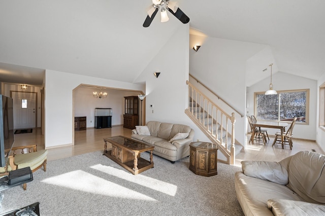 living room featuring light colored carpet, ceiling fan with notable chandelier, and high vaulted ceiling