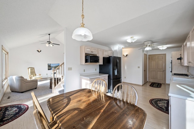 dining room with ceiling fan, light hardwood / wood-style floors, and vaulted ceiling