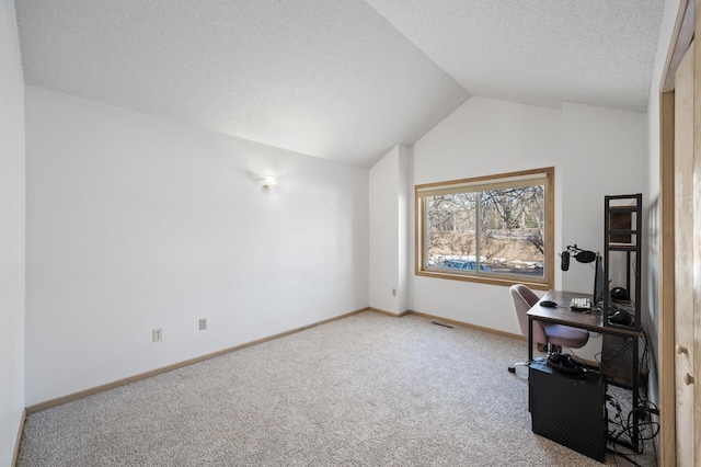 unfurnished office featuring lofted ceiling, carpet flooring, and a textured ceiling