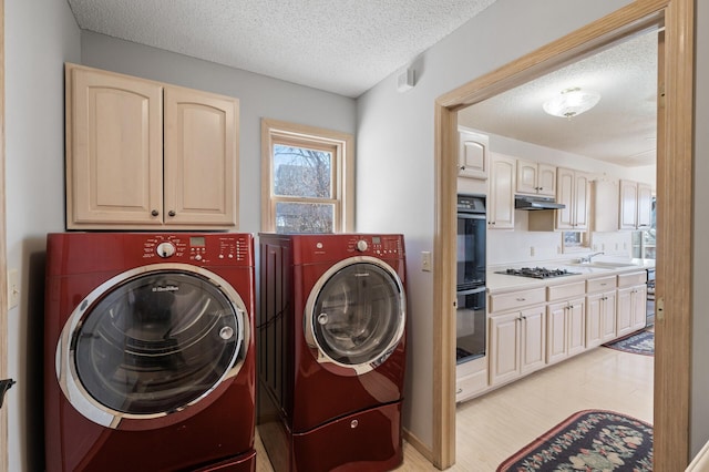 washroom with washer and clothes dryer, sink, a textured ceiling, and light hardwood / wood-style flooring