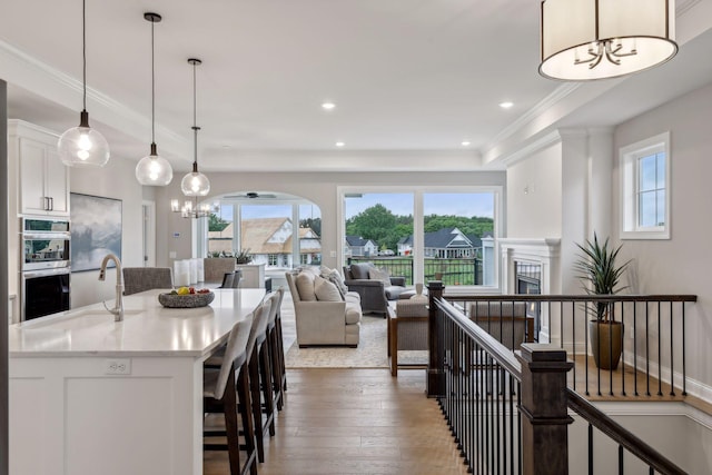 kitchen with white cabinets, hanging light fixtures, and a healthy amount of sunlight