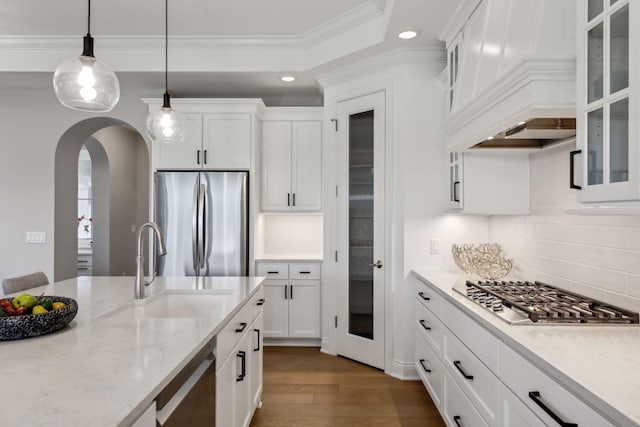 kitchen with tasteful backsplash, dark hardwood / wood-style floors, stainless steel appliances, hanging light fixtures, and white cabinets