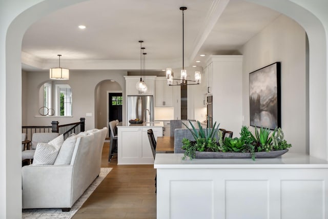 dining room featuring an inviting chandelier, hardwood / wood-style flooring, and ornamental molding