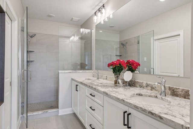 bathroom with an enclosed shower, tile patterned flooring, vanity, and a textured ceiling