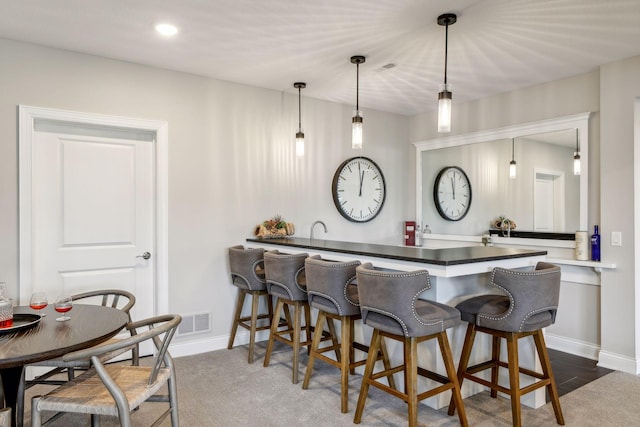 bar featuring decorative light fixtures and dark hardwood / wood-style flooring