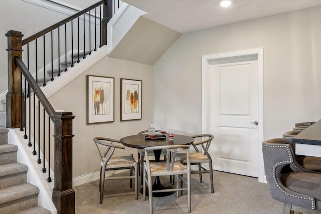 dining room featuring carpet floors and vaulted ceiling