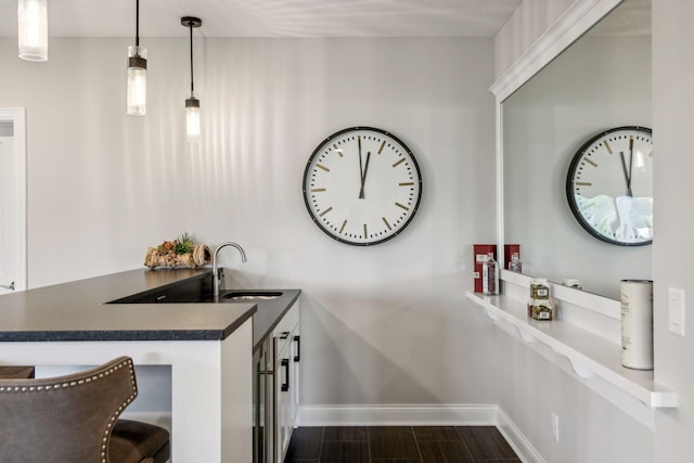 interior space featuring hanging light fixtures, dark hardwood / wood-style floors, and sink