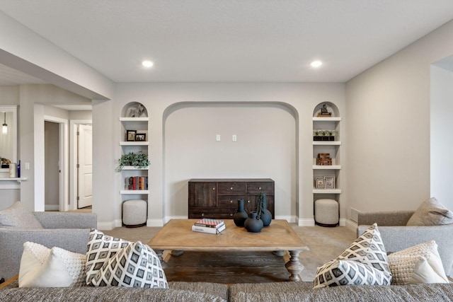 living room with built in shelves and light colored carpet