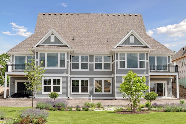 back of property featuring a yard and a balcony