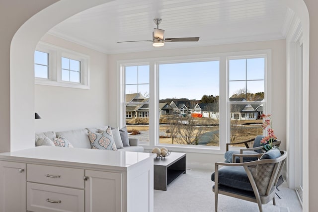 sunroom with arched walkways and ceiling fan