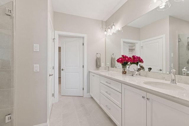 bathroom with a sink, baseboards, a stall shower, and double vanity