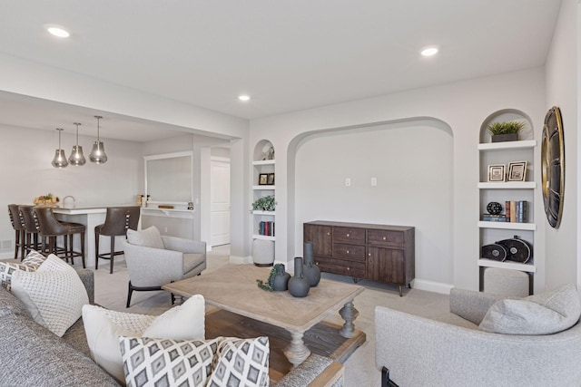 living room with recessed lighting, built in shelves, and baseboards