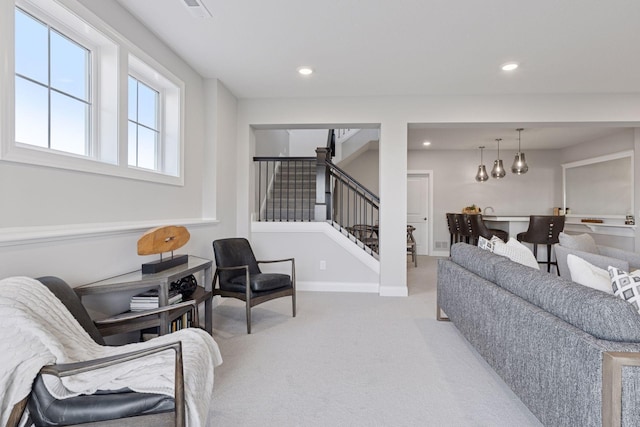 living room with stairway, recessed lighting, light colored carpet, and baseboards