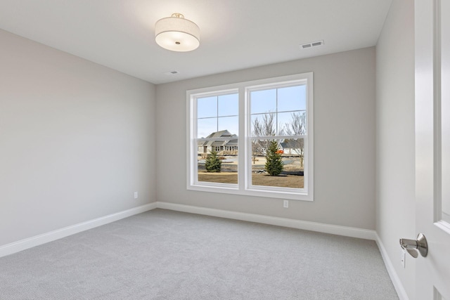 carpeted spare room featuring baseboards and visible vents