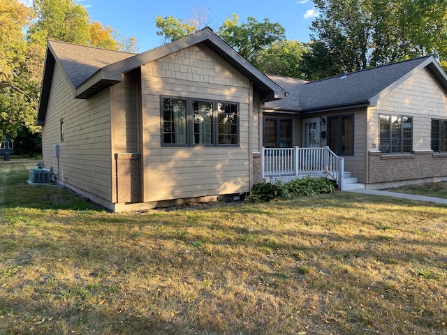 view of front facade featuring a front yard and central AC