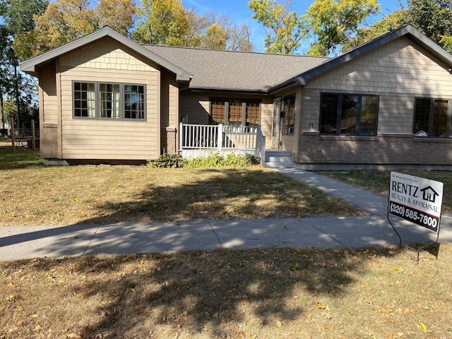 ranch-style home featuring a porch and a front yard