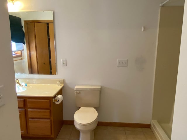 bathroom with walk in shower, vanity, tile patterned flooring, and toilet