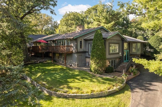 view of front of house with a front yard and a wooden deck