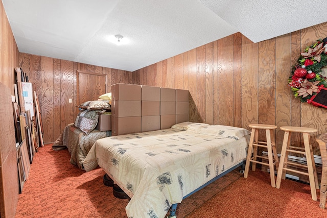 bedroom with carpet floors, wooden walls, and a textured ceiling