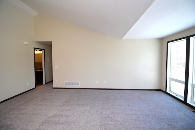 spare room with lofted ceiling and light colored carpet