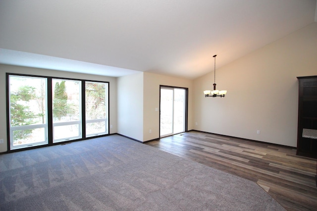 empty room with vaulted ceiling and a notable chandelier