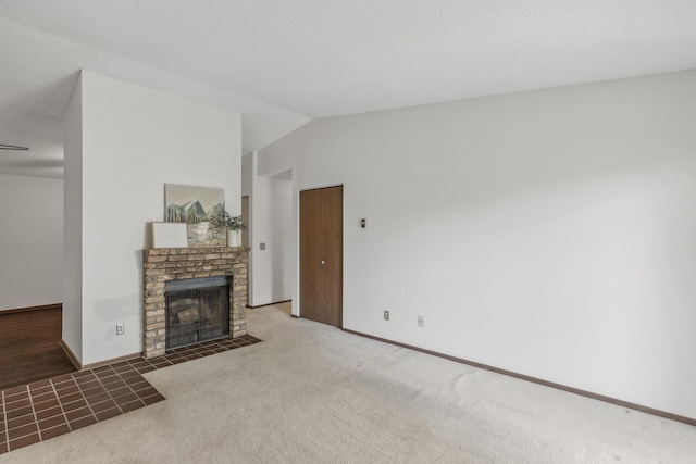 living room featuring lofted ceiling, a fireplace, and dark colored carpet